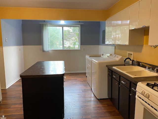 laundry area featuring washing machine and clothes dryer, dark hardwood / wood-style floors, and sink