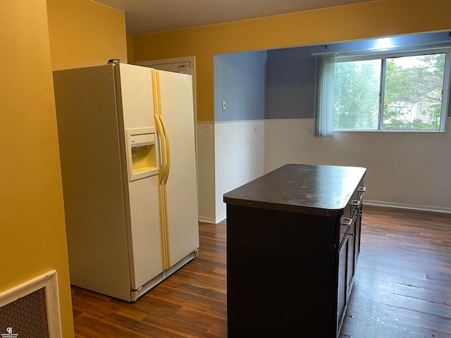 kitchen featuring a kitchen island, white fridge with ice dispenser, and dark hardwood / wood-style flooring