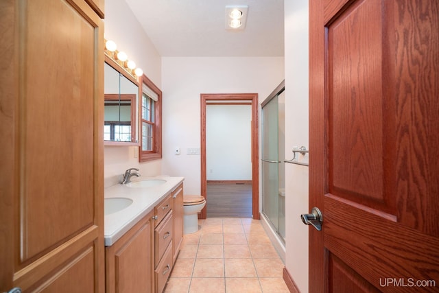 23 Chipman Dr, Ishpeming, MI 49849 - full bathroom featuring toilet, double vanity, an enclosed shower, tile patterned flooring, and baseboards