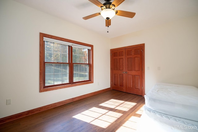 23 Chipman Dr, Ishpeming, MI 49849 - unfurnished bedroom with wood finished floors, baseboards, and a ceiling fan