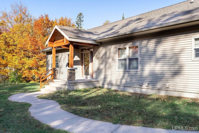 23 Chipman Dr, Ishpeming, MI 49849 - doorway to property with a yard, covered porch, and roof with shingles