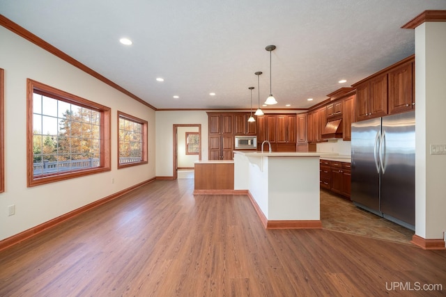 23 Chipman Dr, Ishpeming, MI 49849 - kitchen with appliances with stainless steel finishes, wood finished floors, crown molding, light countertops, and a center island with sink