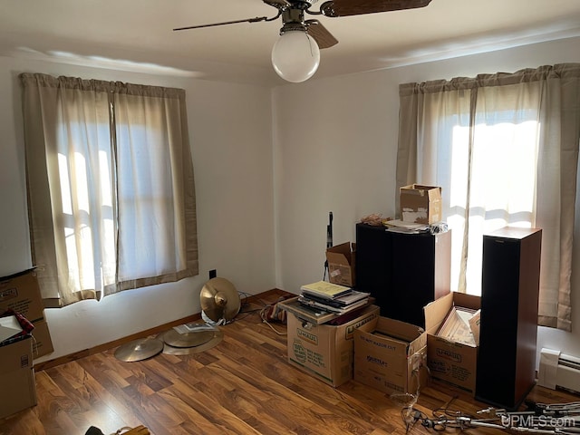 miscellaneous room with ceiling fan, hardwood / wood-style flooring, and a baseboard heating unit