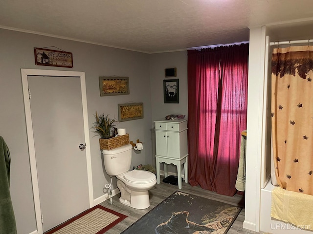 bathroom featuring shower / bath combo, hardwood / wood-style floors, and toilet