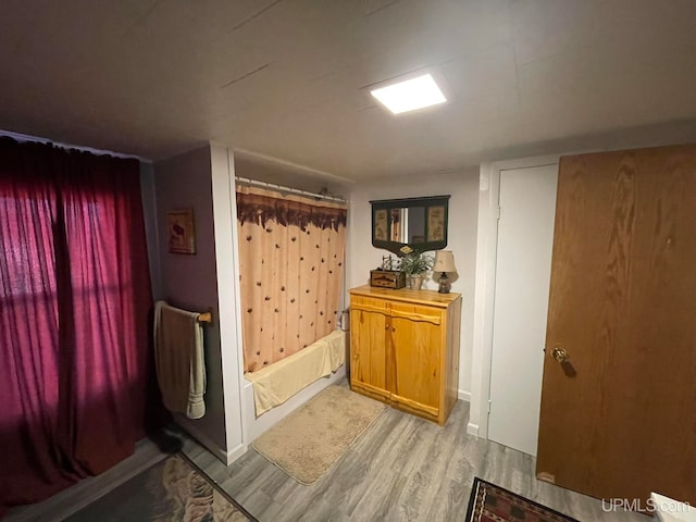 bathroom with shower / bath combo and hardwood / wood-style floors