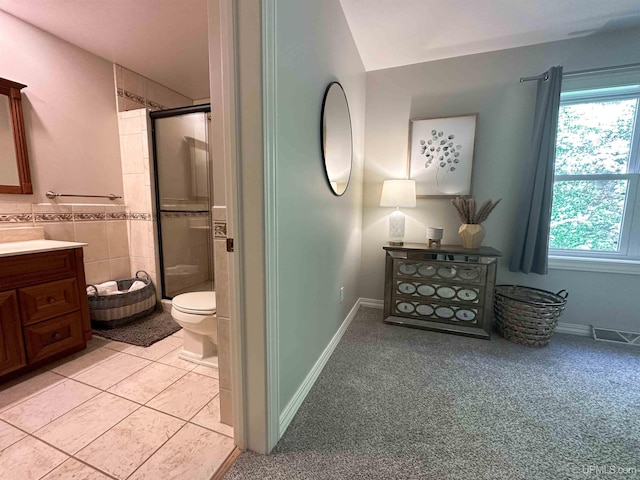 bathroom featuring tile patterned flooring, an enclosed shower, vanity, and toilet