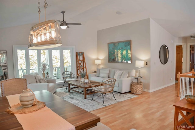 living room with lofted ceiling, french doors, hardwood / wood-style flooring, and ceiling fan