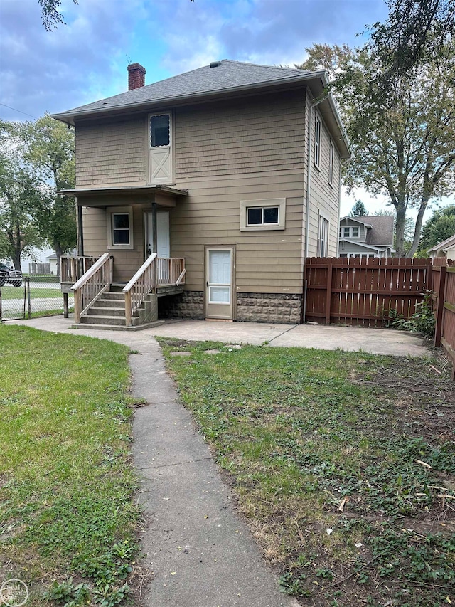 rear view of property with a lawn