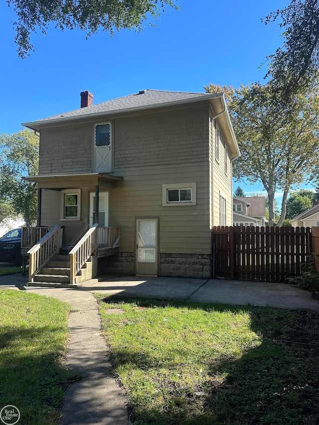 back of property featuring a lawn