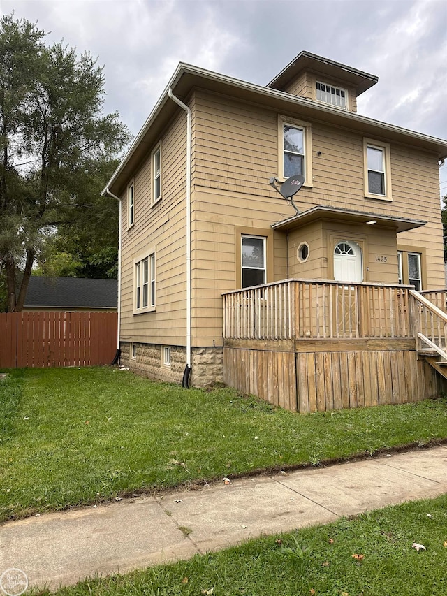 exterior space with a wooden deck and a front yard