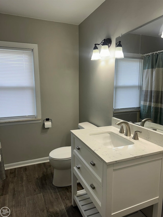 bathroom featuring toilet, vanity, and hardwood / wood-style flooring