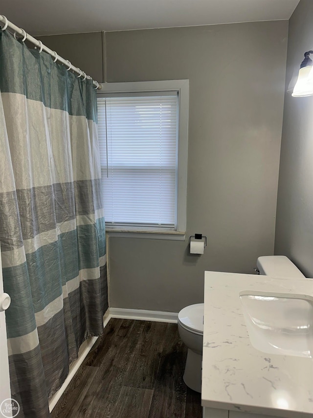 bathroom featuring hardwood / wood-style floors, vanity, toilet, and walk in shower