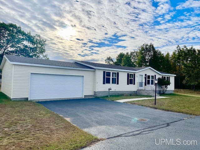 single story home with a garage and a front lawn