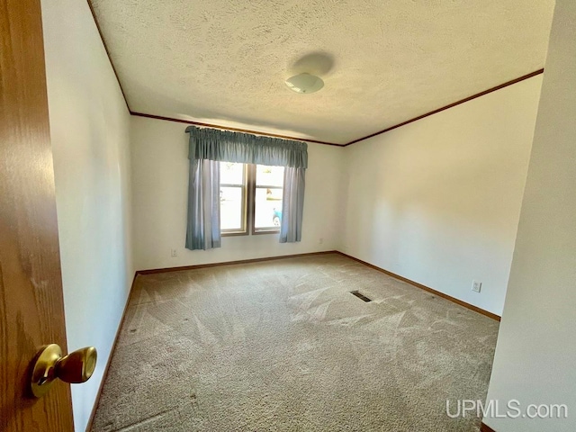 unfurnished room featuring carpet floors, a textured ceiling, and ornamental molding