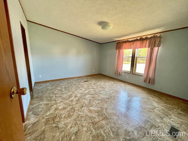 spare room with a textured ceiling and crown molding