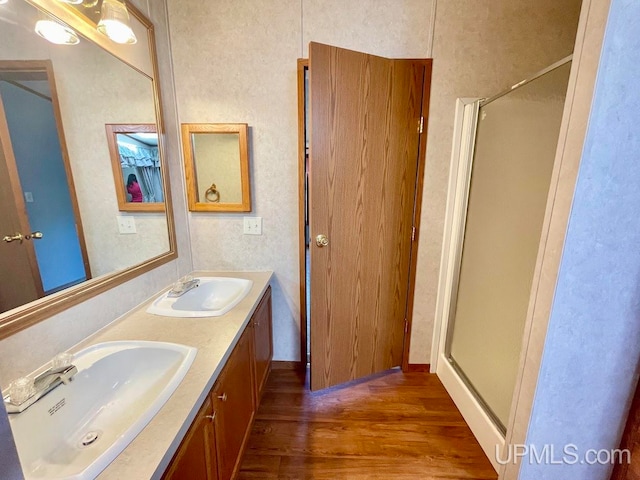 bathroom featuring vanity, hardwood / wood-style floors, and a shower with shower door