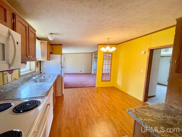 kitchen featuring light hardwood / wood-style floors, white appliances, pendant lighting, crown molding, and sink