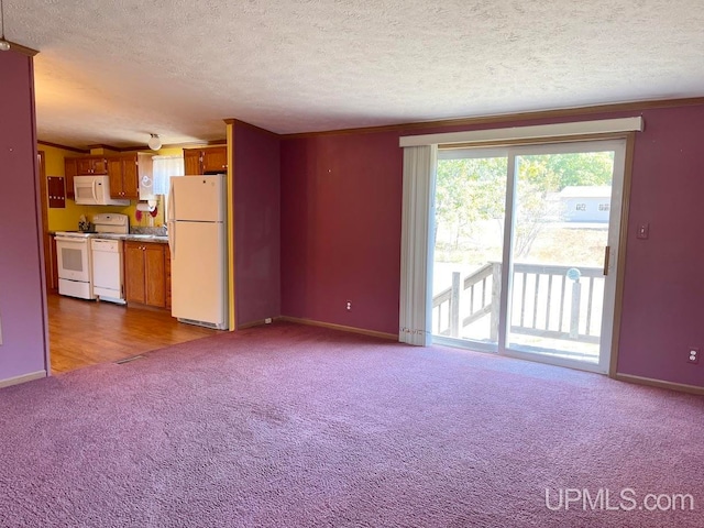 unfurnished living room featuring carpet floors, a textured ceiling, and ornamental molding