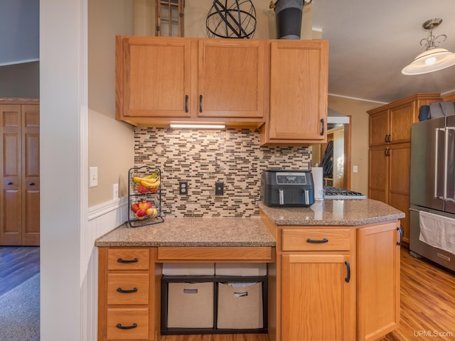 kitchen with light hardwood / wood-style flooring, decorative backsplash, and high end fridge