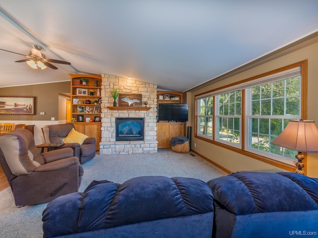 carpeted living room with a fireplace, vaulted ceiling, ceiling fan, and built in features