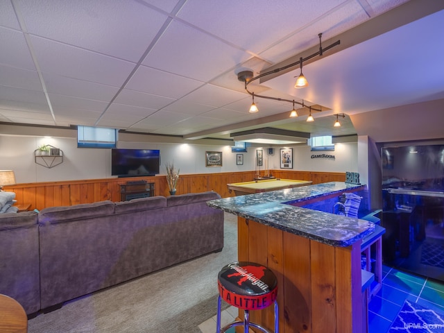 bar with wooden walls, track lighting, carpet floors, and a paneled ceiling