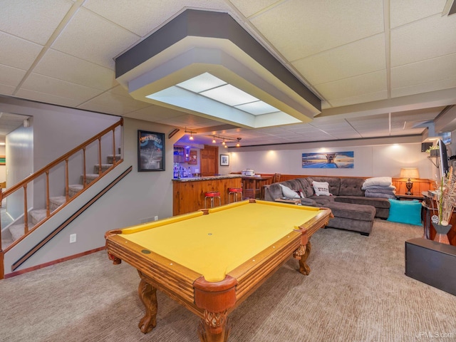 rec room with a paneled ceiling, carpet, bar area, and billiards