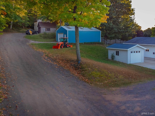 view of front facade with an outdoor structure, a garage, and a front lawn