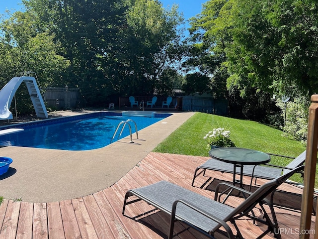 view of swimming pool with a yard and a water slide