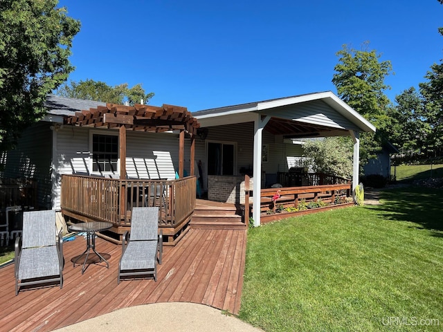 back of property featuring a lawn, a pergola, and a wooden deck