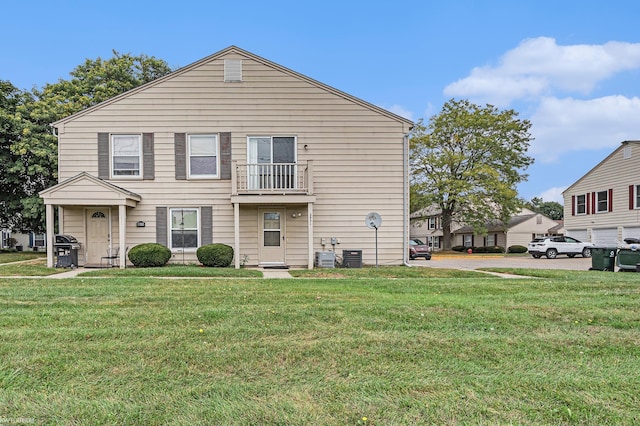 view of front of home featuring a balcony, a front lawn, and central air condition unit