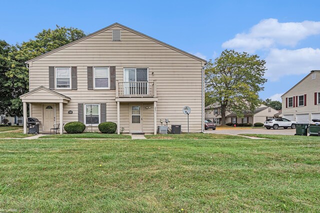 view of front of property with a front lawn, cooling unit, and a balcony