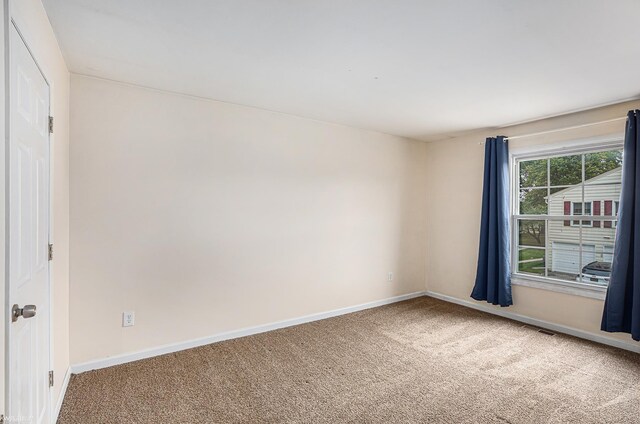 carpeted empty room with visible vents and baseboards