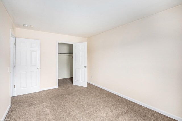 unfurnished bedroom with a closet, baseboards, and carpet flooring