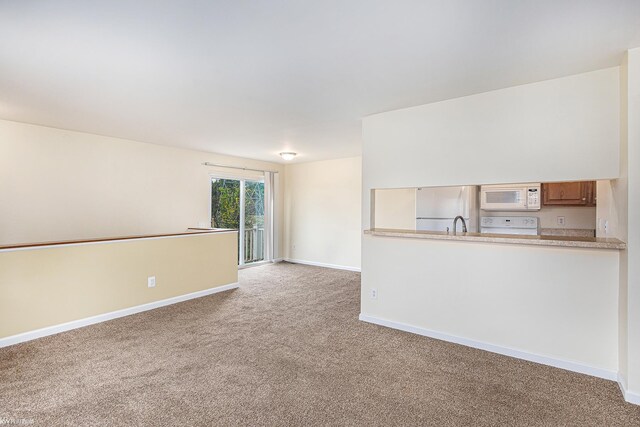 unfurnished living room with baseboards and carpet floors