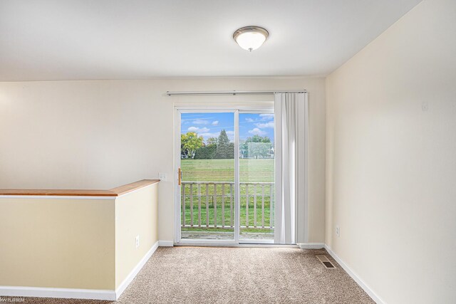 carpeted spare room with visible vents and baseboards