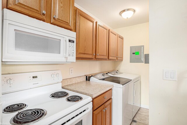 clothes washing area featuring washer and clothes dryer, laundry area, electric panel, and baseboards