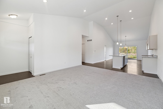 unfurnished living room featuring dark wood-type flooring and high vaulted ceiling