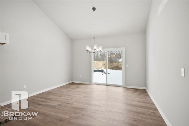 1440 Lincoln St, Lapeer, MI 48446 - unfurnished dining area with wood finished floors, a chandelier, baseboards, and lofted ceiling