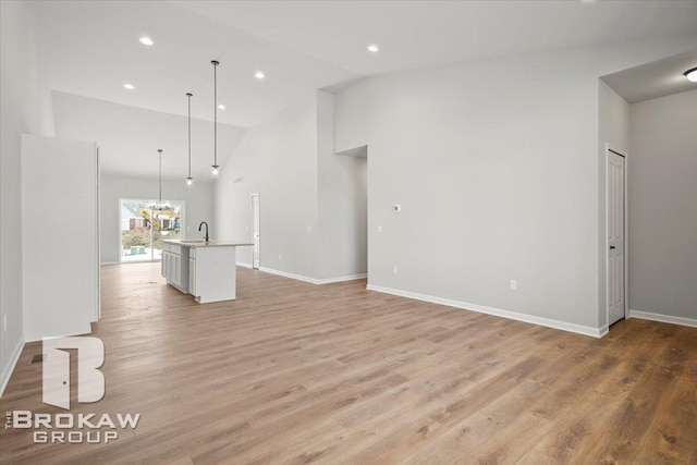1440 Lincoln St, Lapeer, MI 48446 - unfurnished living room with high vaulted ceiling, a chandelier, light wood-style floors, baseboards, and recessed lighting