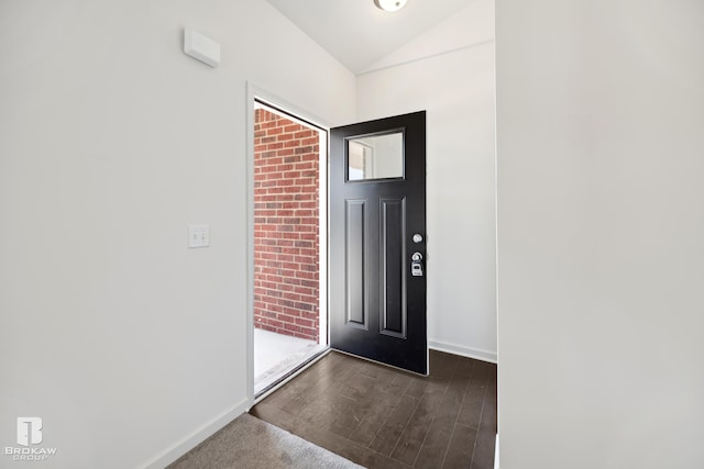 entryway with dark wood-type flooring and lofted ceiling