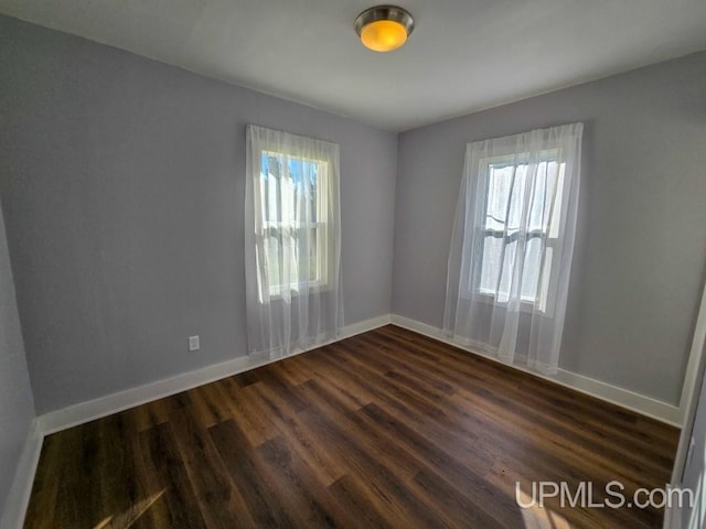 spare room with dark hardwood / wood-style flooring