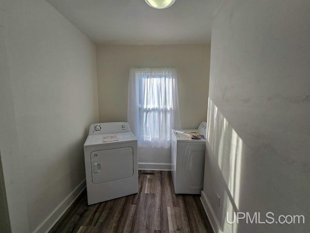 laundry room featuring washing machine and clothes dryer and dark hardwood / wood-style flooring