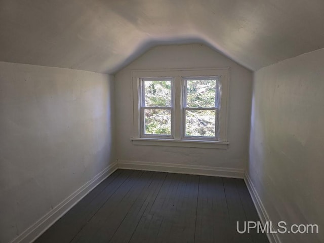 bonus room featuring vaulted ceiling and dark hardwood / wood-style flooring