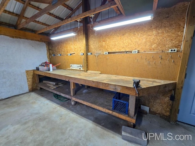 miscellaneous room featuring lofted ceiling, a workshop area, and concrete floors