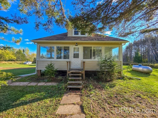 bungalow with a sunroom and a front yard