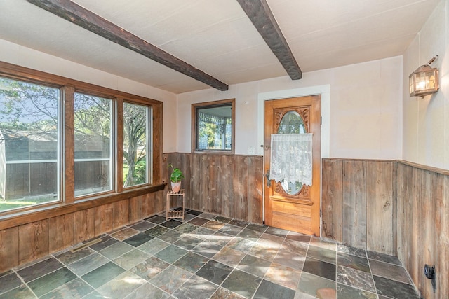 interior space featuring wooden walls and beamed ceiling