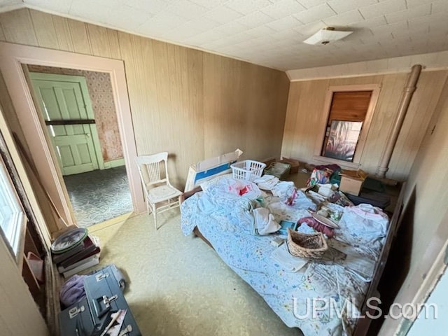 bedroom with wooden walls and carpet