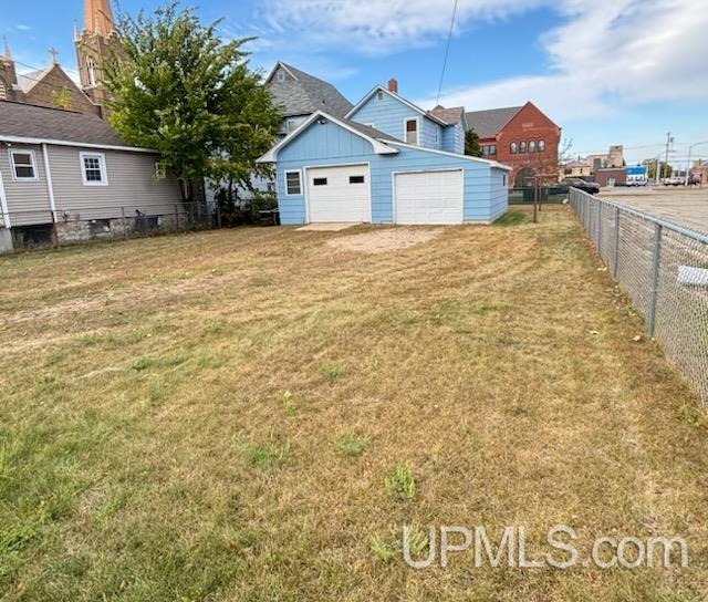 view of yard featuring a garage and an outdoor structure