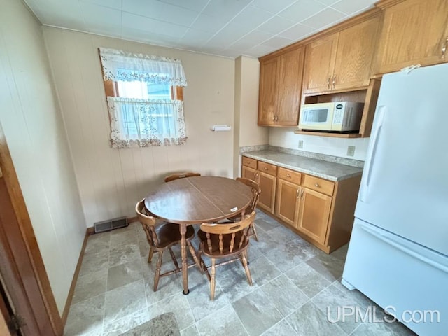 kitchen featuring wooden walls and white appliances