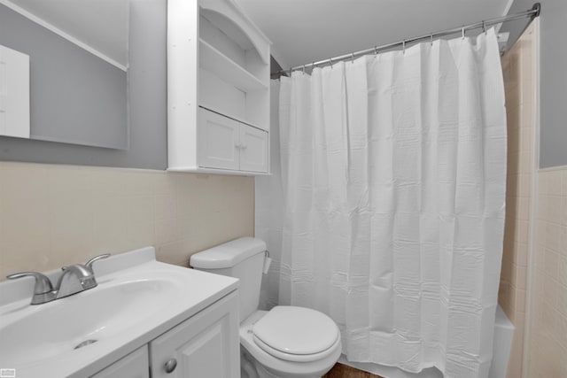 full bathroom featuring vanity, tile walls, toilet, and shower / bath combo